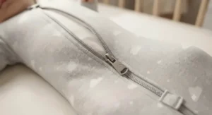Close-up of the secure two-way zipper on a baby swaddle transition bag for easy nighttime diaper changes.