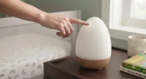Close-up of a hand tapping a touch control smart LED nursery night light to change brightness